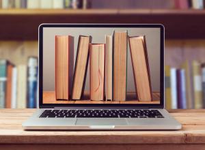 row of books on laptop monitor