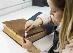 Paper conservator Jen Snowden working on Francis Austen’s mathematics coursebook from the Royal Naval Academy at Portsmouth.