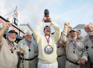 Surrounded by previous winners of the Hemingway Look-Alike Contest, 2026 champion Chris Dutton hoists his trophy, a bronze bust of Nobel Prize-winning author Ernest Hemingway, outside Sloppy Joe’s Bar.